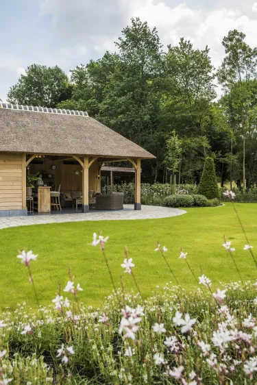 Klassieke groene tuin met traditioneel tuinhuis inclusief lounge