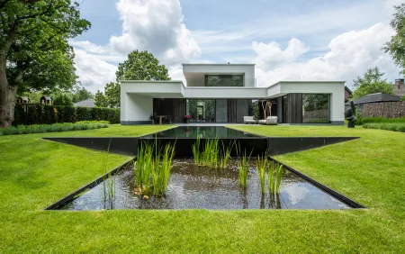 Achtertuin modern wit huis met zwemvijver