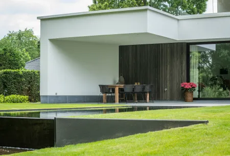 Eethoek modern wit huis met zwemvijver. 