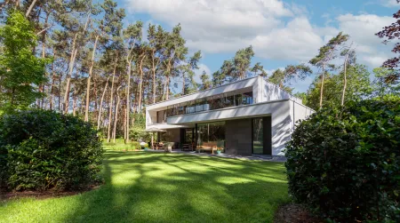 Moderne villa te midden bos omringd door groene tuin
