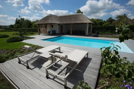 Klassieke tuin met zwembad en traditioneel poolhouse inclusief lounge