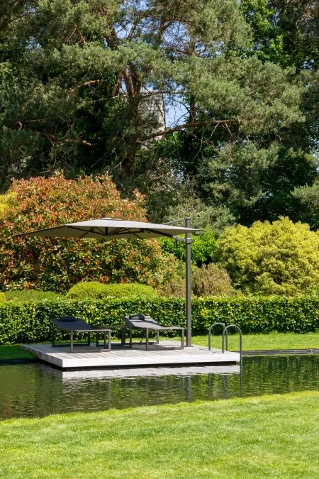 Organische zwemvijver met zonneterras aan klassieke villa