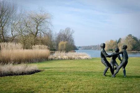 Landschappelijke tuin met kunstwerk met uitzicht op meer