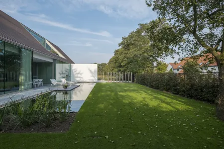 Achtertuin villa met grote raampartijen en zwemvijver