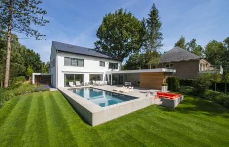 Villa met zwembad en lounge, omringd door groene omgeving