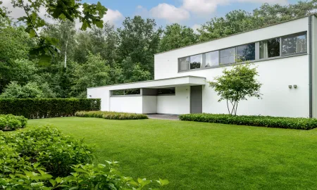 Zijkant moderne villa met groene tuin