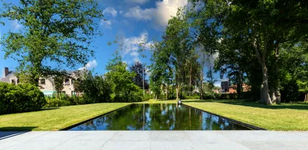Overloop zwemvijver in groene omgeving aan moderne villa