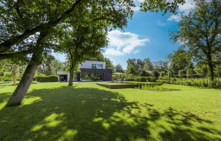 Groene tuin met zwemvijver aan moderne villa te Keerbergen