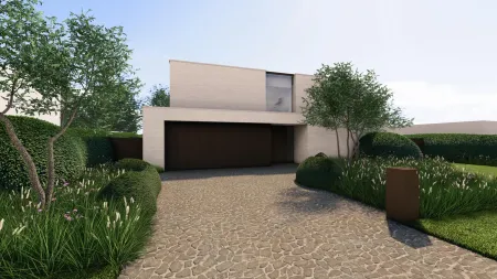 Grindoprit met strakke beplanting leidt naar de moderne, minimalistische voorgevel van de villa in Rijmenam.